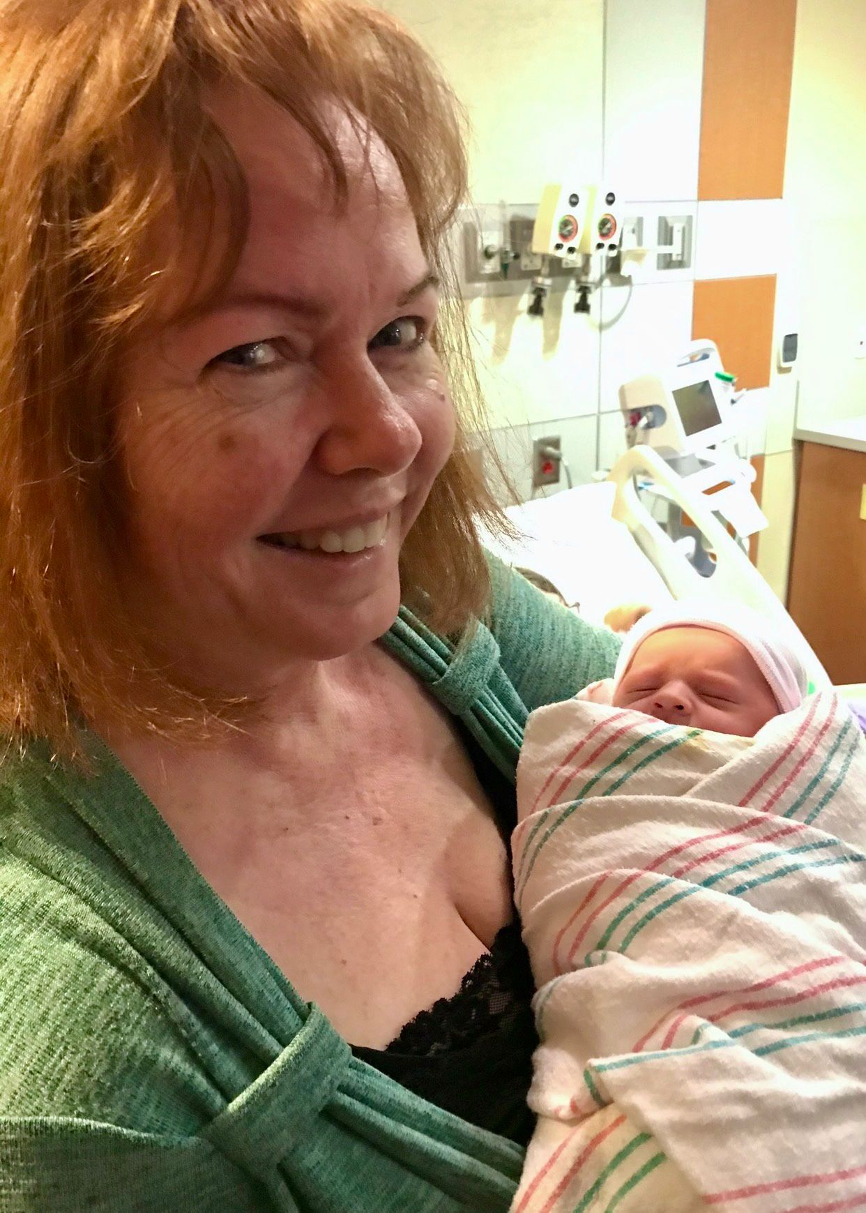 Sandy smiling while holding a newborn